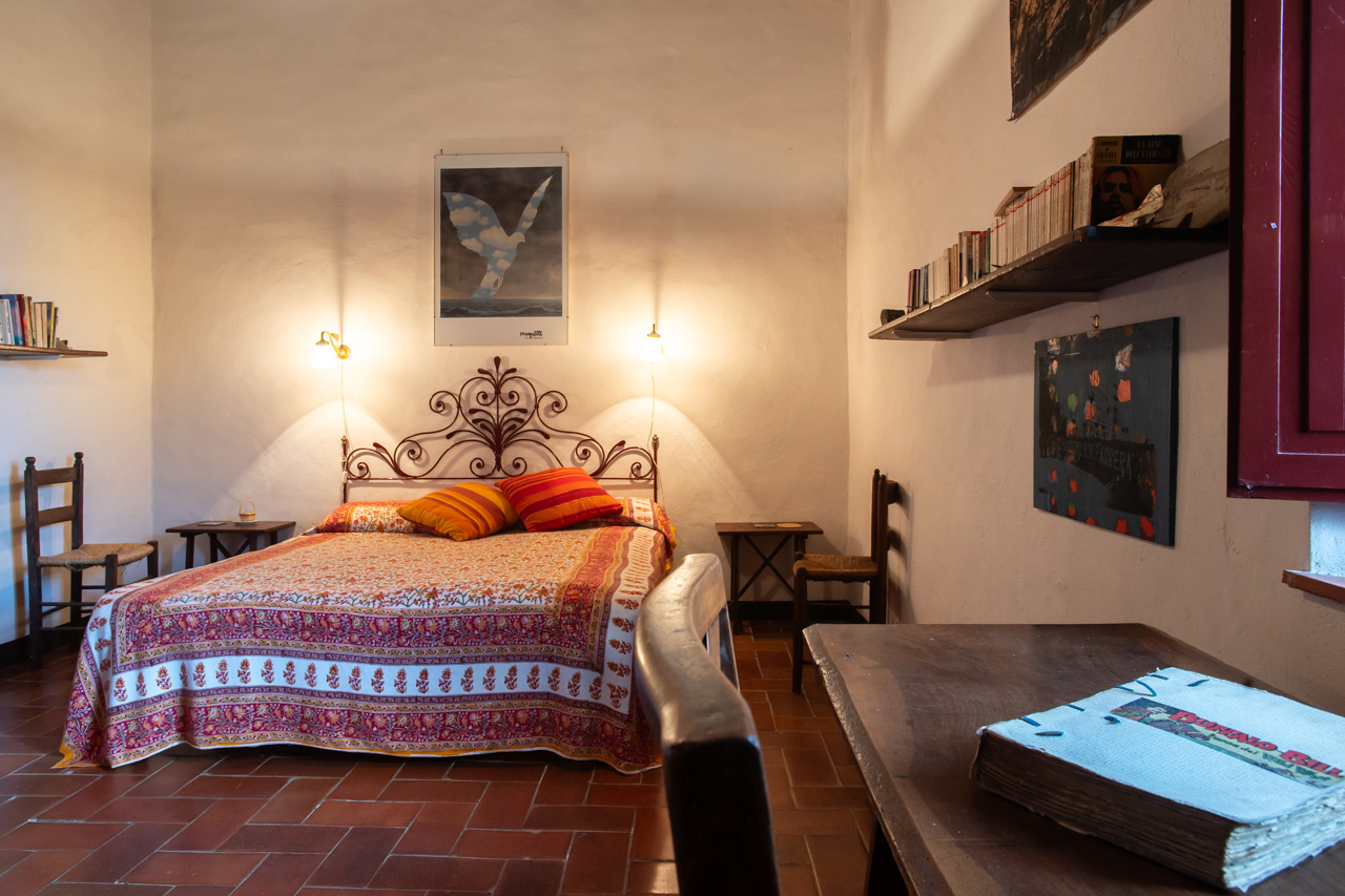 Bedroom with iron headboard and terracotta floor