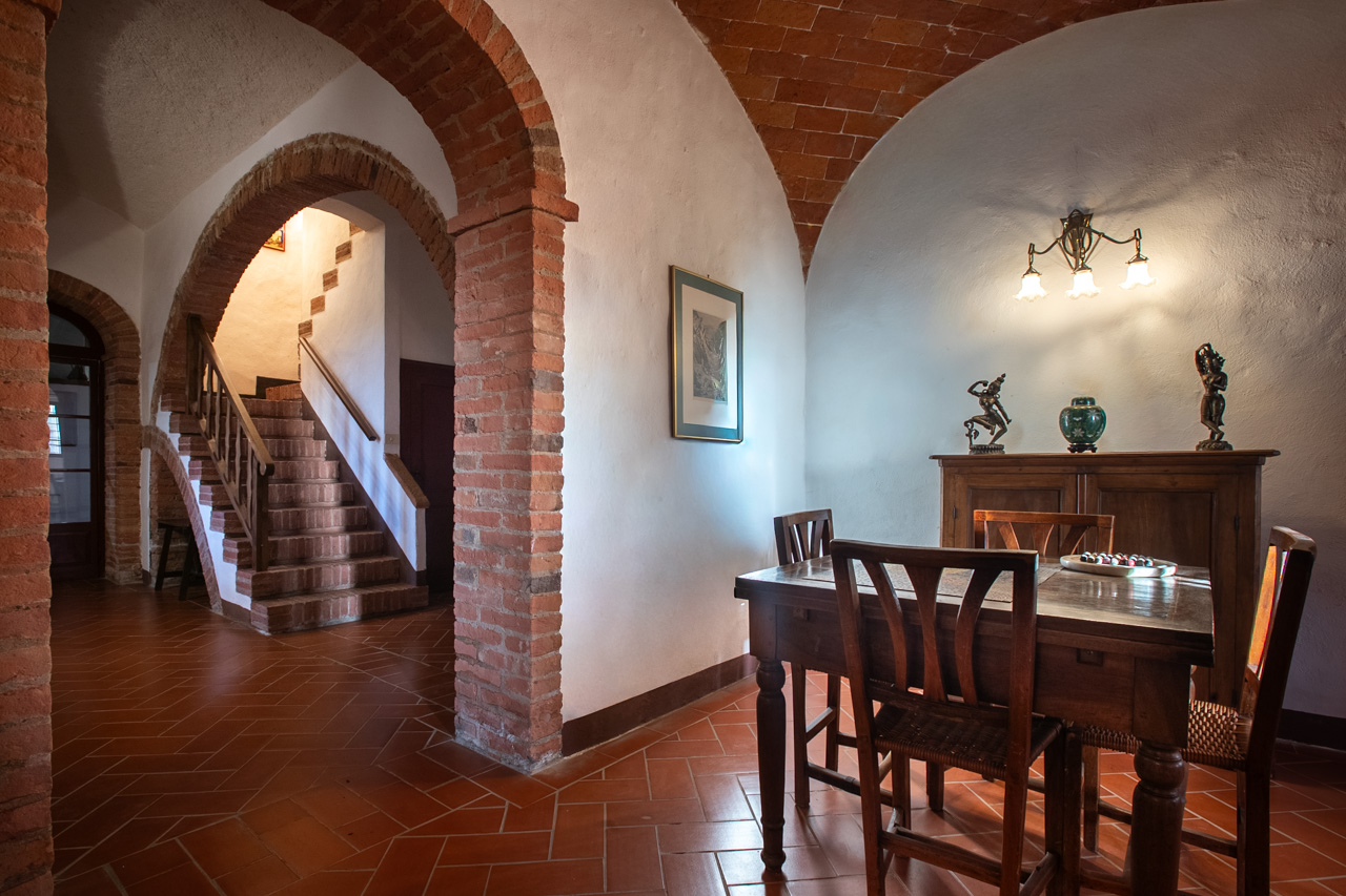 Vaulted brick arches and dining area inside Podere Casanova
